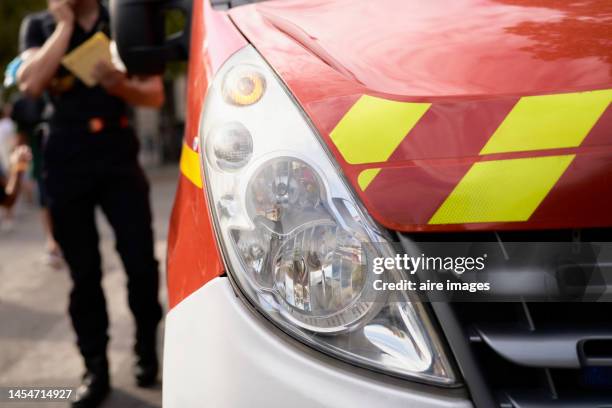 uniformed man holding an object and with the other hand calling out, standing next to a relevant vehicle, to a relevant authority. - ambulance bildbanksfoton och bilder