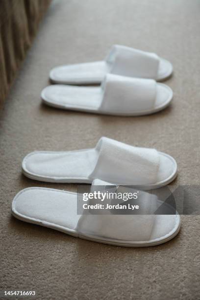 two pairs of white toweling hotel disposable slippers - hotel room white bed stock pictures, royalty-free photos & images