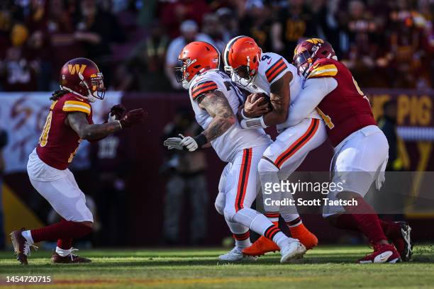 Daron Payne of the Washington Commanders sacks Deshaun Watson of the Cleveland Browns during the first half of the game at FedExField on January 1,...