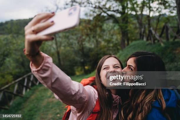 ein junges erwachsenes paar macht ein selfie während eines bergurlaubs - couple tongue kissing stock-fotos und bilder
