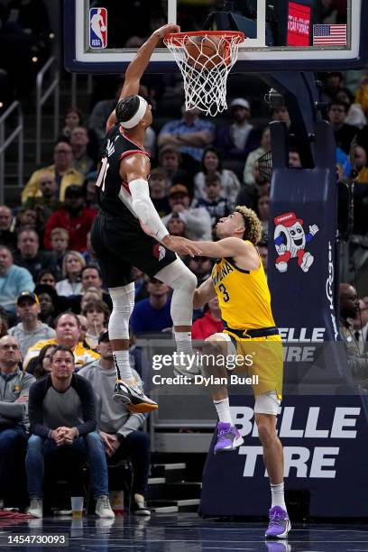 Josh Hart of the Portland Trail Blazers dunks the ball over Chris Duarte of the Indiana Pacers in the third quarter at Gainbridge Fieldhouse on...