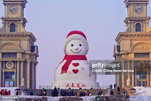 Tourists visit an 18-meter-tall snowman at Harbin Music Park ahead of Chinese New Year, the Year of the Rabbit, on January 6, 2023 in Harbin,...