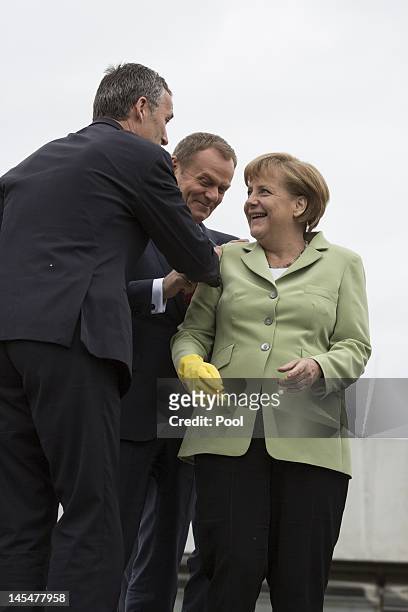 Norwegian Prime Minister Jens Stoltenberg, Polish Prime Minister Donald Tusk and German Chancellor Angela Merkel feed the penguins on the roof of the...