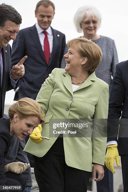 European Commission President Jose Manuel Barroso and German Chancellor Angela Merkel feed the penguins on the roof of the Baltic Sea aquarium during...