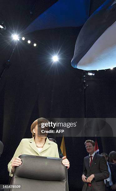 German Chancellor Angela Merkel stands under a model of whale at the Ozeaneum sea museum during the opening plenary session of the summit of the...