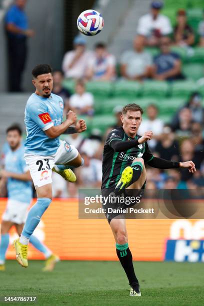 Neil Kilkenny of Western United kicks the ball under pressure from Marco Tilio of Melbourne City during the round 11 A-League Men's match between...