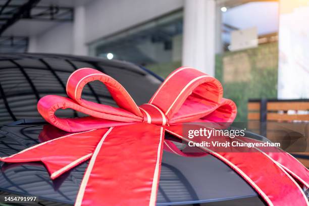 new car with red ribbon and red bow - bow stock pictures, royalty-free photos & images