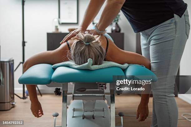 trattamento fisioterapico per alleviare il dolore della paziente femminile - osteopata foto e immagini stock