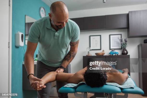 physiotherapy treatment for pain relief of male patient - osteopathie stockfoto's en -beelden