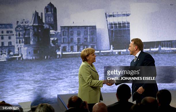German chancellor Angela Merkel and Russian Federation's First Deputy Prime Minister Igor Shuvalov shake hands after a press conference at the end of...