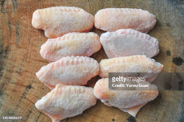 frozen raw chicken wings on the cutting board. - hühnchenbrust stock-fotos und bilder