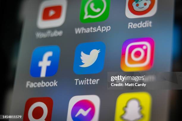 In this photo illustration the logo of US online social media and social networking service Twitter is displayed on a smartphone screen on January...