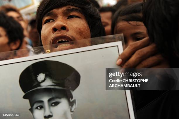 Supporter of Myanmar opposition leader Aung San Suu Kyi holds up a portrait of her father and independence hero general Aung San as Suu Kyi delivers...