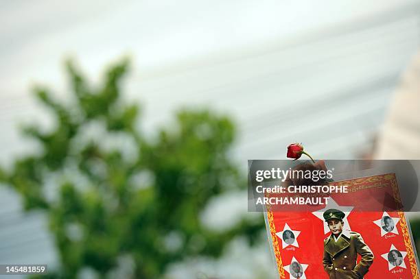 Supporter of Myanmar opposition leader Aung San Suu Kyi holds up a portrait of her father and independence hero General Aung San as Suu Kyi delivers...