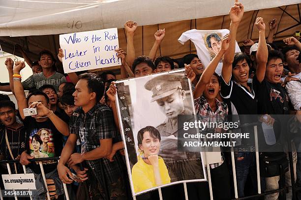 Supporters of Myanmar opposition leader Aung San Suu Kyi hold portraits of her and her father and independence hero General Aung San as they wait for...