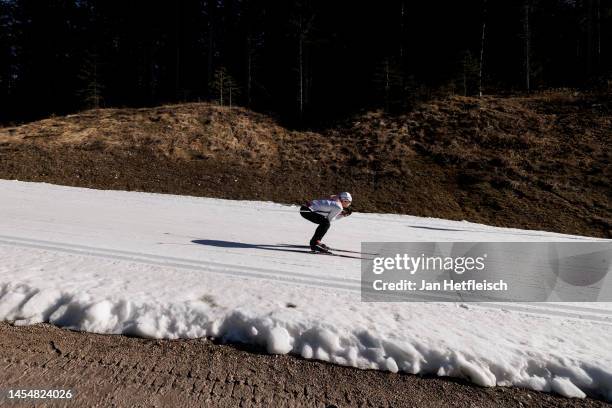 Cross-country skier runs on a track covered with artificial snow as grass covers the rest of the area on both sides on January 07, 2023 in Seefeld,...