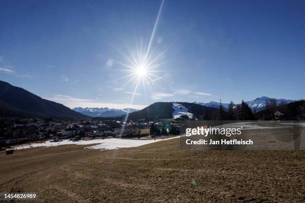 Skiers descend on a slope covered in artificial snow as grass covers the rest of the hill on either side on January 07, 2023 in Seefeld, Austria....
