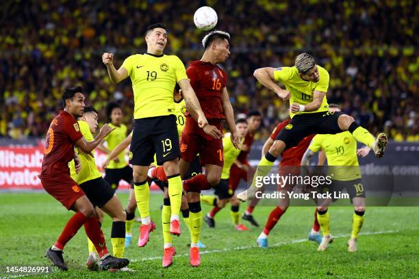 Jakkapan Praisuwan of Thailand competes for a header off a corner kick against Ezequiel Aguero and Brendan Gan of Malaysia in the second half during...