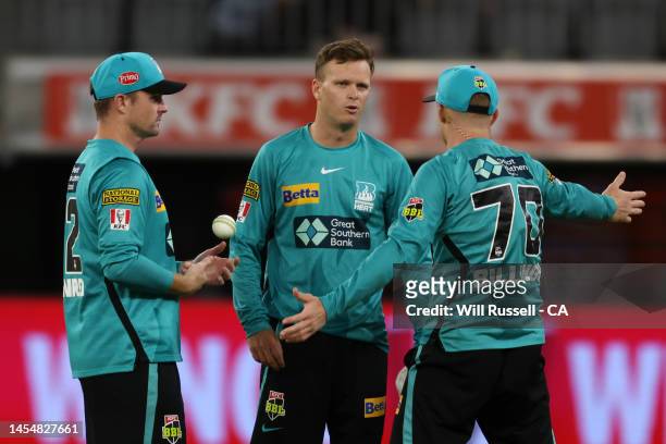 Colin Munro, Matt Kuhnemann and Sam Billings of the Heat talk during the Men's Big Bash League match between the Perth Scorchers and the Brisbane...