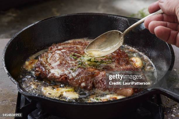 pan searing beef eye rib steak - bañar en su jugo durante la cocción fotografías e imágenes de stock