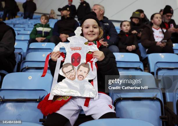 Wrexham fan with a home made foil FA Cup trophy with images of owners Ryan Reynolds and Rob McElhenney on along with film character Deadpool ahead of...