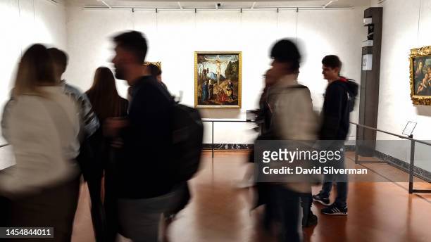 Visitors pass in front of the painting Crucifixion, dated to 1500-1505, by the Italian renaissance artist Marco Palmezzano at the Uffizi Gallery on...