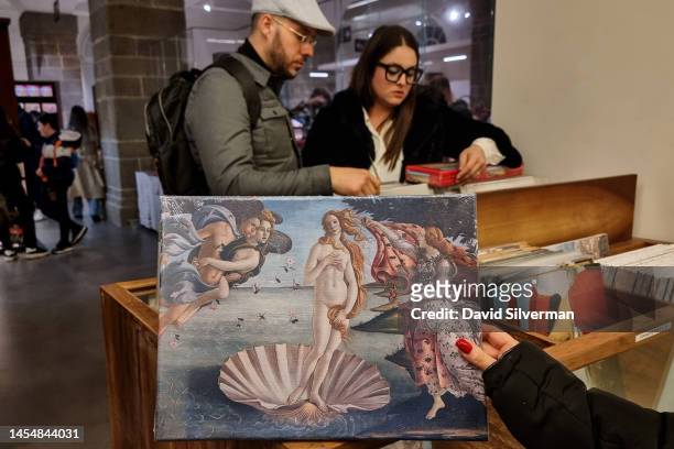 Visitors shop for souvenirs, showing the iconic painting The Birth of Venus by the 15th century Italian Renaissance artist Sandro Botticelli, at the...