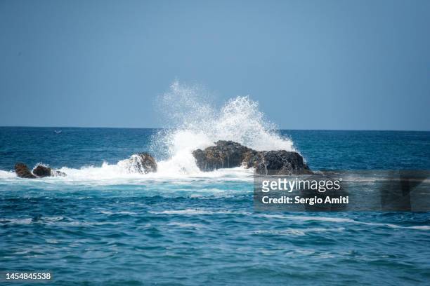waves crashing on rocks on fishermen bay beach at cidade velha on santiago island, cape verde. - cidade velha stock-fotos und bilder