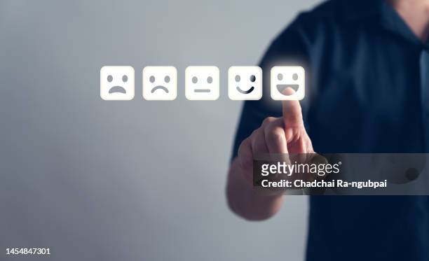 customer service and satisfaction concept ,business people are touching the virtual screen on the happy smiley face icon to give satisfaction in service. rating very impressed - customer relations management foto e immagini stock