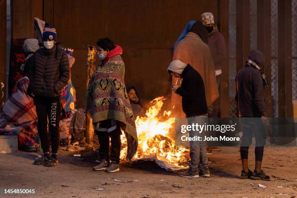 Immigrants wait overnight next to the U.S.-Mexico border fence to seek asylum in the United States on January 07, 2023 as viewed from Ciudad Juarez,...