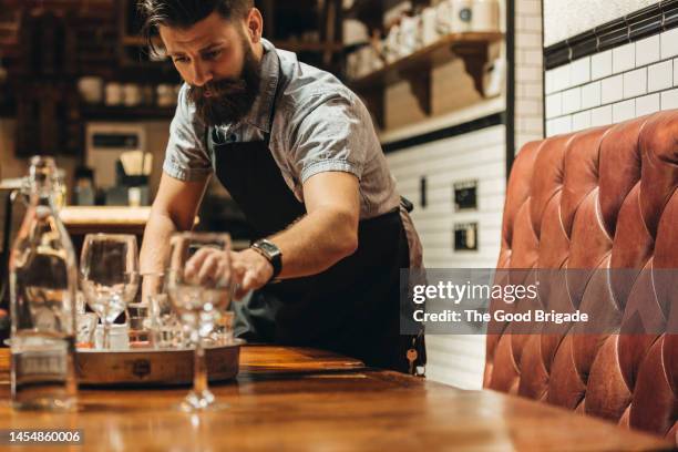 waiter clearing table in restaurant - empty glass stock pictures, royalty-free photos & images