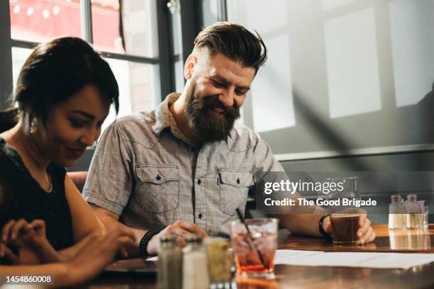 young couple enjoying date in bar - restaurant atmosphere stock pictures, royalty-free photos & images