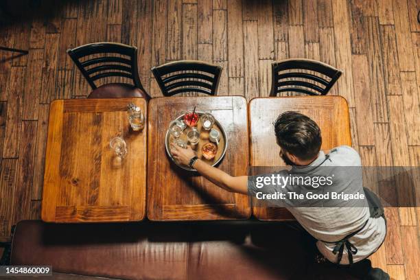 high angle view of waiter clearing table in bar - café vu de haut photos et images de collection