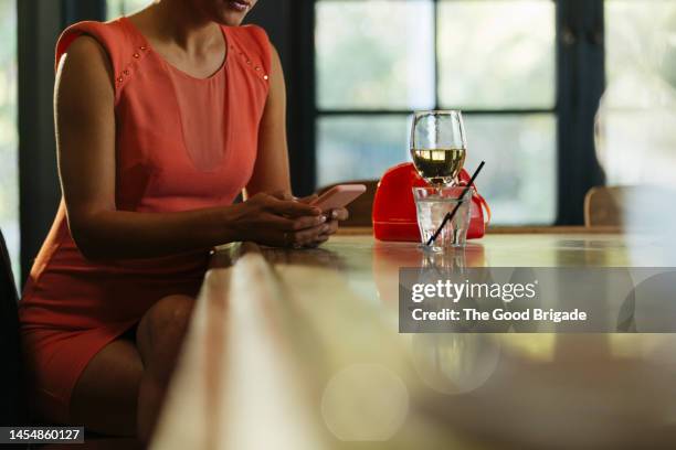 midsection of woman with using smart phone in bar - encontro entre desconhecidos imagens e fotografias de stock