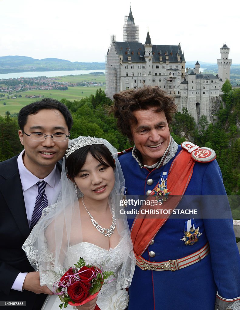 A Chinese wedding couple pose in front o