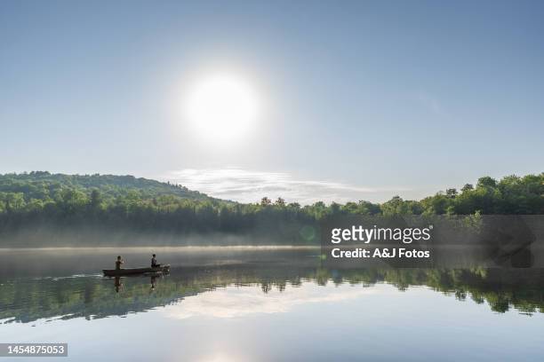 couple canoeing in early morning. - two people canoeing on a lake stock pictures, royalty-free photos & images