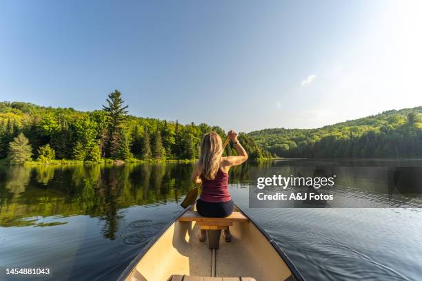 a woman canoeing in early morning. - weekend activities stock pictures, royalty-free photos & images