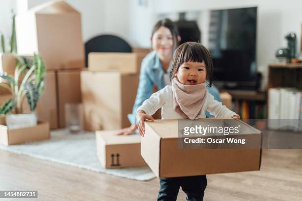 asian family moving to a new home together - asian young family stockfoto's en -beelden