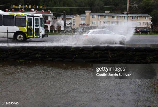 Car drives through a section of roadway that is beginning to flood as rain begins to fall on January 07, 2023 in Mill Valley, California. The San...