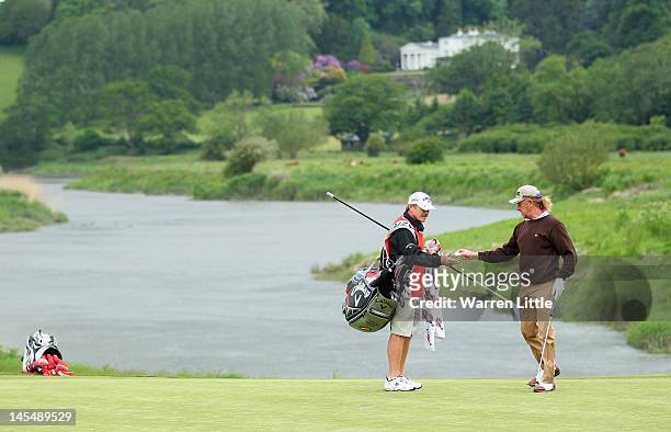 Miguel Angel Jimenez of Spain hands his ball to a caddie during the first round of the ISPS Handa Wales Open on the Twenty Ten course at the Celtic...