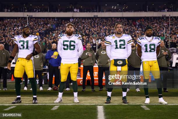 Adrian Amos, Jack Coco, Aaron Rodgers, and Randall Cobb of the Green Bay Packers stand on the sidelines during the national anthem prior to an NFL...