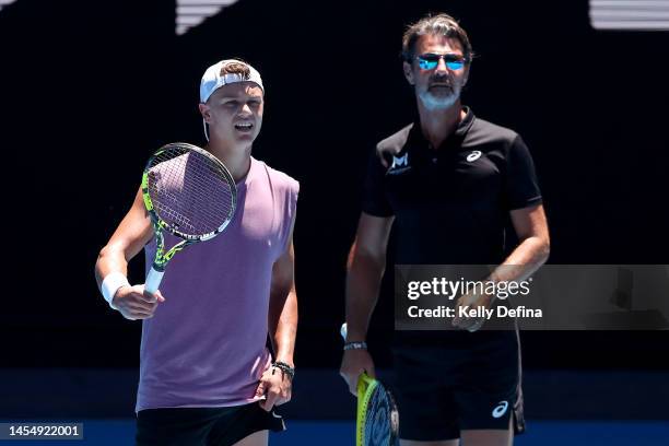 Holger Rune of Denmark speaks with Patrick Mouratoglou during a practice session ahead of the 2023 Australian Open at Melbourne Park on January 08,...