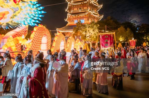 Tourists wearing Chinese traditional costumes watch an illuminated lantern during a lantern show at Xiamen Fantawild Dreamland as 2023 Chinese Spring...