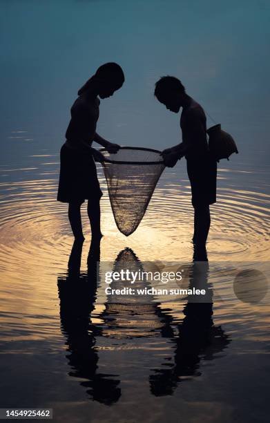 boy fishing in the river - kids at river stock-fotos und bilder