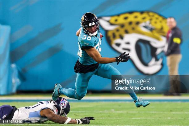 Jamal Agnew of the Jacksonville Jaguars jumps over Lonnie Johnson Jr. #20 of the Tennessee Titans during the third quarter at TIAA Bank Field on...