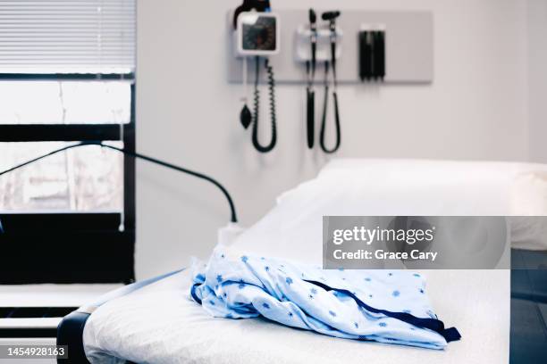 medical gown on examination table in doctor's office - abortion hospital stock pictures, royalty-free photos & images