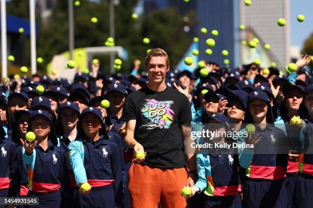 Denis Shapovalov of Canada poses with 2023 Australian Open ballkids during a media opportunity ahead of the 2023 Australian Open at Melbourne Park on...