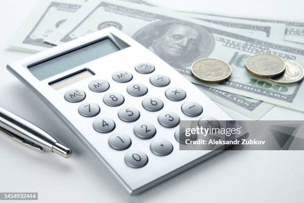 calculator, pen and dollar bills. the concept of financial accounting, calculation of business profit or loss, management of expenses and income. investing, business and the global crisis. lending and insurance. salary, bribe or credit funds. - viaje barato fotografías e imágenes de stock