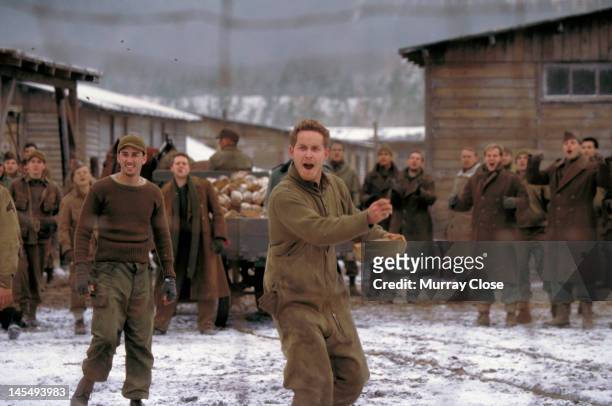 Actor Cole Hauser throwing bread to Russian prisoners-of-war in a scene from the film 'Hart's War', 2002.