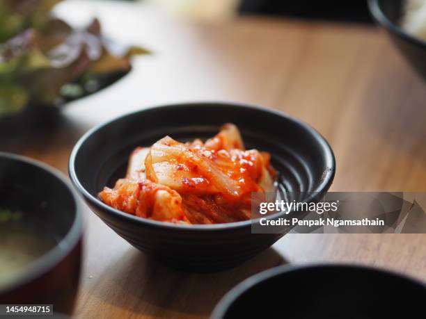 kimchi, kimchee in black bowl on table - kimchi stock pictures, royalty-free photos & images